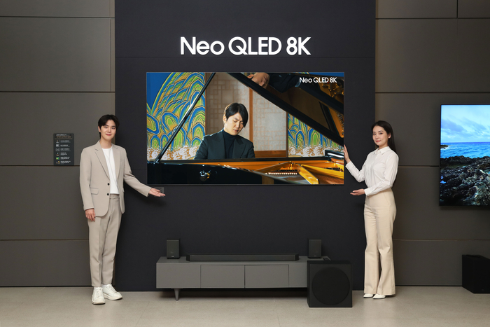 삼성전자 모델이 삼성스토어 대치점에서 Neo QLED 8K TV로 파이니스트 조성진의 8K 라이브 연주 영상을 감상하고 있다.