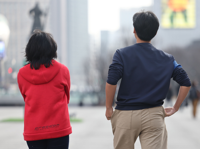 서울 광화문광장에서 한 시민이 포근한 날씨로 소매를 걷은 채 걸어가고 있다.연합뉴스