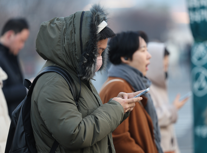 서울 종로구 광화문네거리에서 두꺼운 외투를 입은 시민들이 횡단보도 신호를 기다리고 있다.연합뉴스