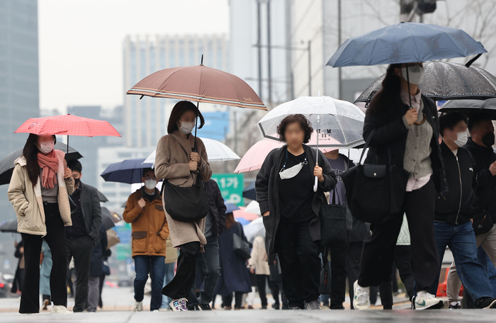 서울 광화문광장에서 곳곳 마스크를 낀 시민들이 우산을 들고 걸어가고 있다.연합뉴스