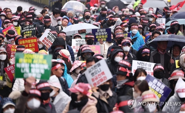 29일 오후 서울 여의도 KB국민은행 본점 앞에서 홍콩지수ELS피해자모임 회원들이 '대국민 금융사기 규탄 집회'를 하고 있다.