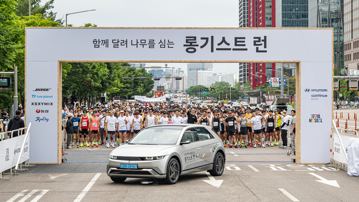 25일 진행된 현대차 '롱기스트 런 2024' 10km 마라톤 대회 '파이널 런' 참가자들이 친환경차 아이오닉 5와 함께 기념촬영을 하고 있다.