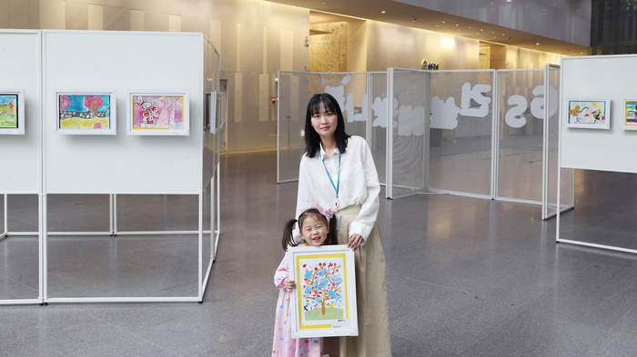 'GS건설에 왔나 봄' 그림전시전에서 임직원이 자녀와 관람하고 있다.