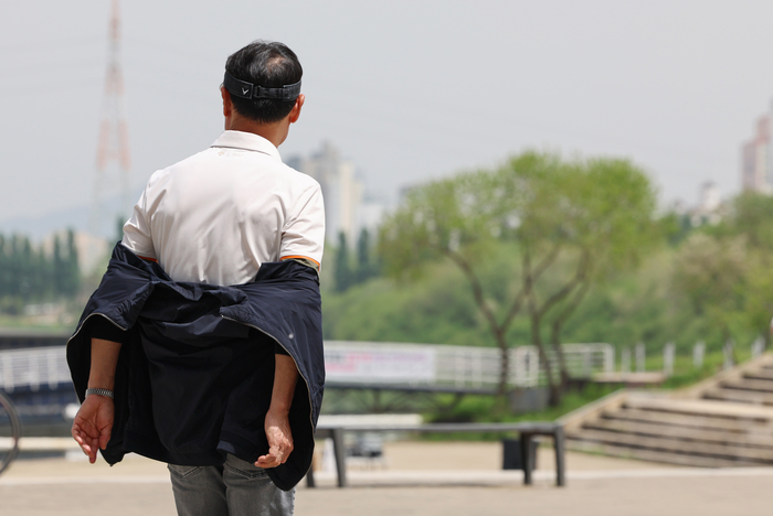 서울 서초구 반포한강공원을 찾은 시민이 겉옷을 반만 입고 있다.연합뉴스