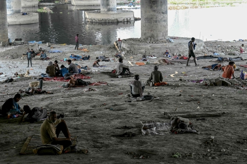 인도 수도 뉴델리를 지나는 야무나강 고가도로 아래서 2024년 5월 31일(현지시간) 노숙자들이 폭염을 피해 쉬고 있다.