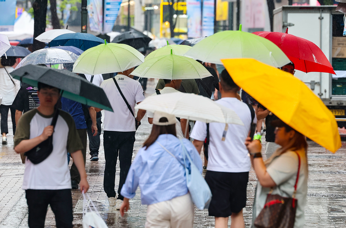 서울 명동거리에 시민들과 관광객들이 우산을 쓰고 이동하고 있다,연합뉴스