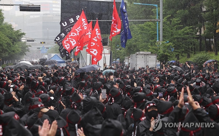 8일 오전 경기도 화성시 삼성전자 화성사업장 앞에서 열린 전국삼성전자노동조합 총파업 결의대회에서 조합원들이 입장하는 깃발을 보며 박수치고 있