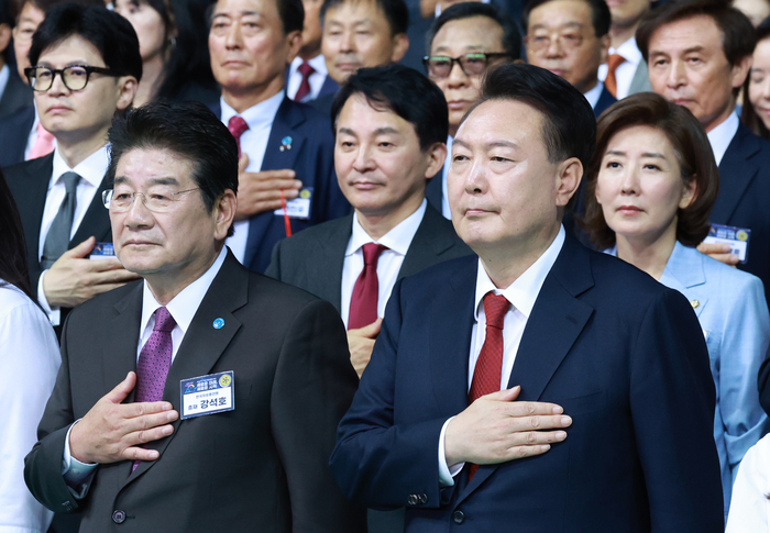 윤석열 대통령이 원희룡 국민의힘 당 대표 후보와 유사한 톤 정장과 같은 색 넥타이를 매고 한국자유총연맹 창립 제70주년 기념식에서 국기에 경례하