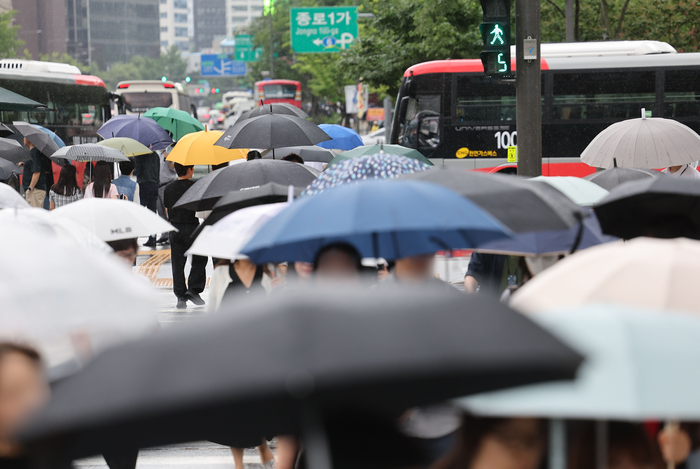 우산을 쓴 시민들이 서울 광화문 사거리를 지나고 있다.연합뉴스