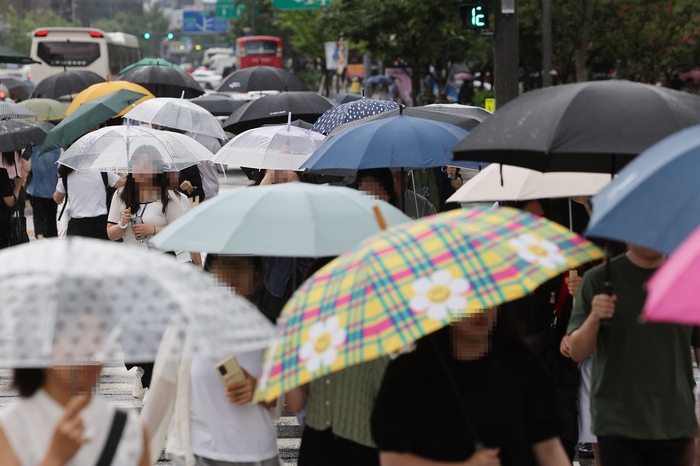 우산을 쓴 시민들이 서울 광화문 사거리를 지나고 있다.연합뉴스