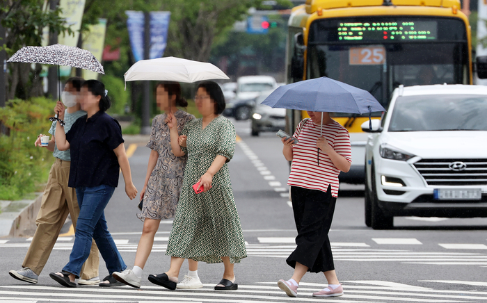 광주 서구 내방로에서 시민들이 갑자기 내리는 비에 우산을 쓰고 걷고 있다.연합뉴스