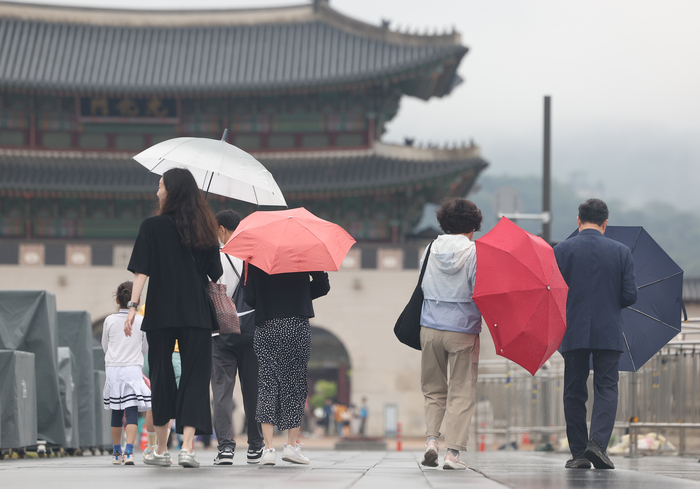 서울 종로구 광화문광장 일대에서 시민들이 우산을 쓰고 이동하고 있다.연합뉴스