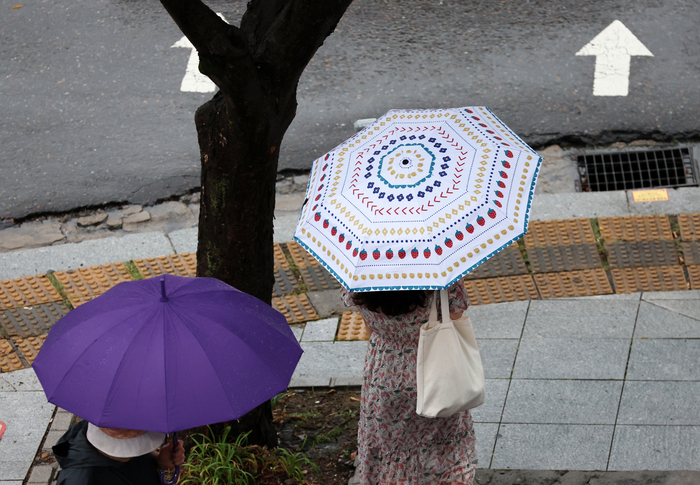 광주 서구 치평동에서 한 시민이 내리는 소나기에 우산을 쓰고 걷고 있다.연합뉴스