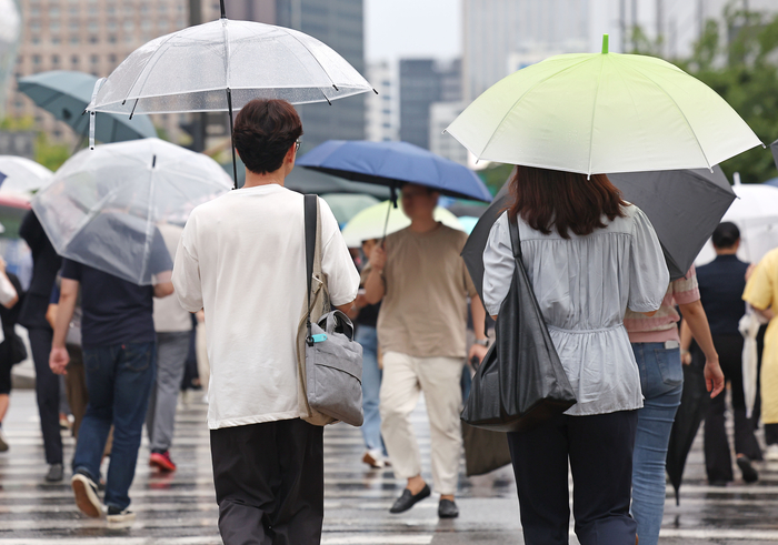 서울 광화문광장에서 시민들이 우산을 쓴 채 걸어가고 있다.연합뉴스